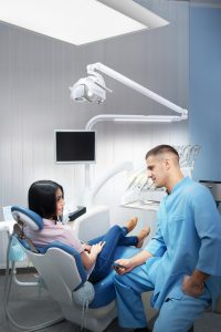 Male dentist talking to a patient in a clinic